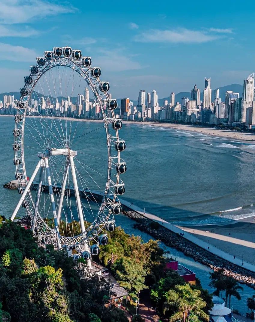 Vista aérea de Balneário Camboriú, com a roda-gigante, a praia e a linha de prédios ao fundo